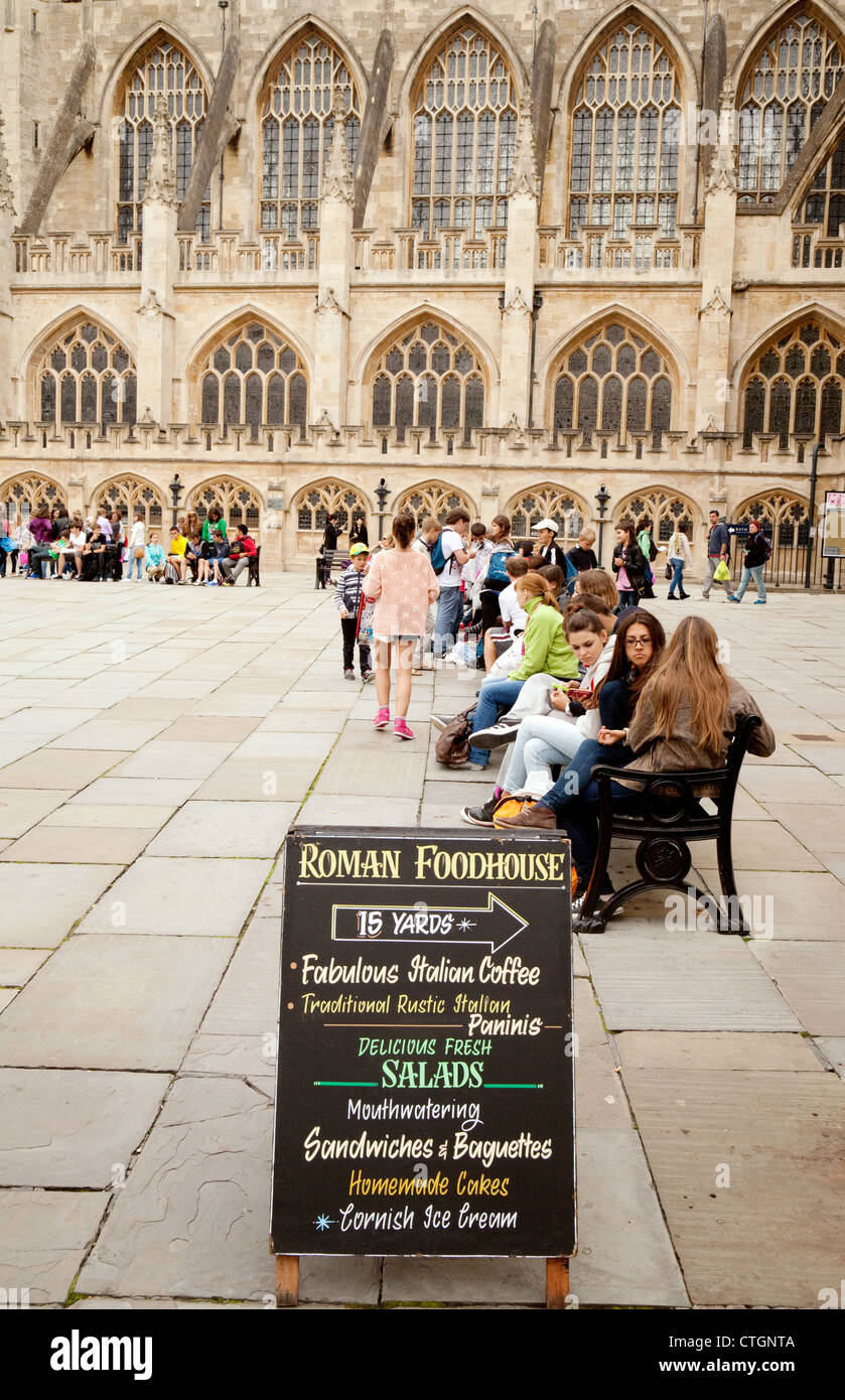 Les gens assis dans la place à côté de l'abbaye, baignoire Somerset UK Banque D'Images