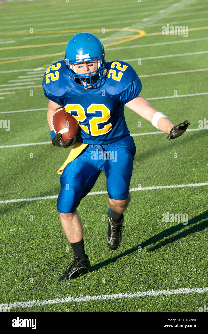 Caucasian football player running with ball Banque D'Images