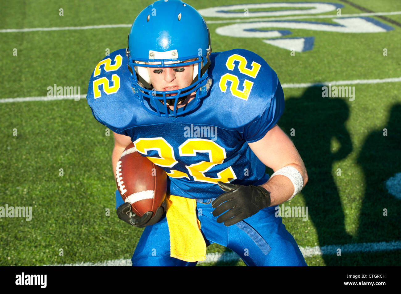 Caucasian football player running with ball Banque D'Images