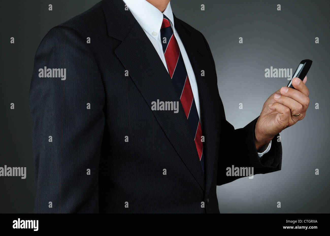 Un homme d'affaires libre de consultation des messages sur son téléphone cellulaire. Format horizontal Banque D'Images