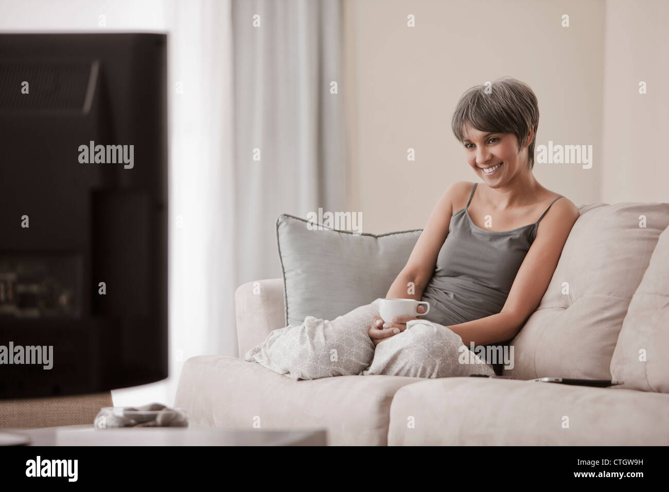 Mixed Race woman relaxing on sofa Banque D'Images