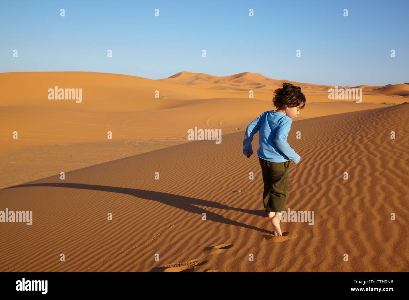 Mixed Race boy running in desert Banque D'Images