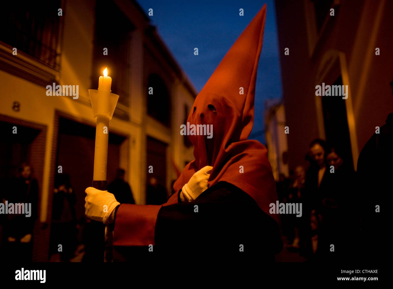 Le pénitent est titulaire d'une bougie lors d'une procession de la Semaine Sainte de Pâques à Puente Genil, dans la province de Cordoba, Espagne Banque D'Images