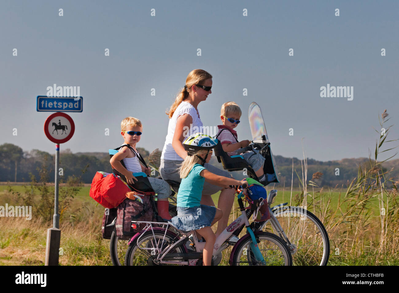 Les Pays-Bas, West Kapelle, femme et enfants à vélo. Banque D'Images