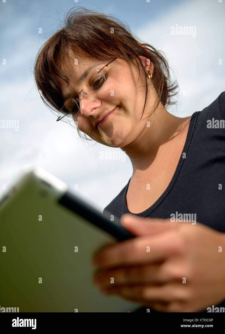 Jeune femme portant des lunettes works with tablet computer Banque D'Images