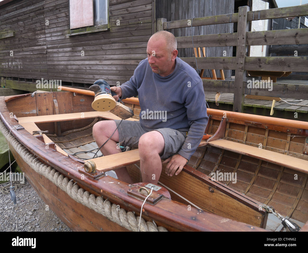 Réparateur de bateau vers le bas, à Southwold bois ponçage Harbour Banque D'Images