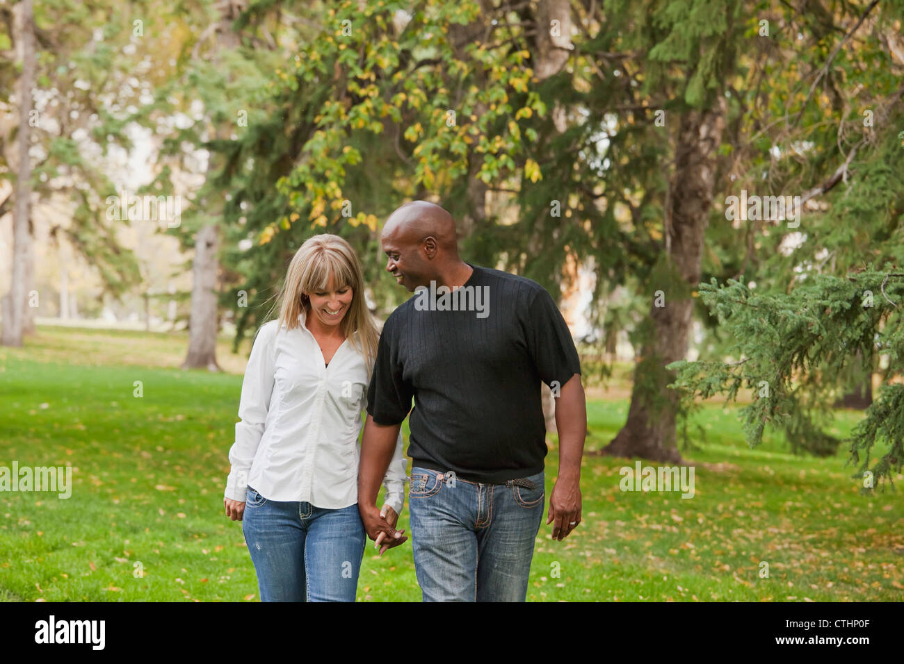 L'Interracial Couple Walking in a park in autumn ; Edmonton, Alberta, Canada Banque D'Images