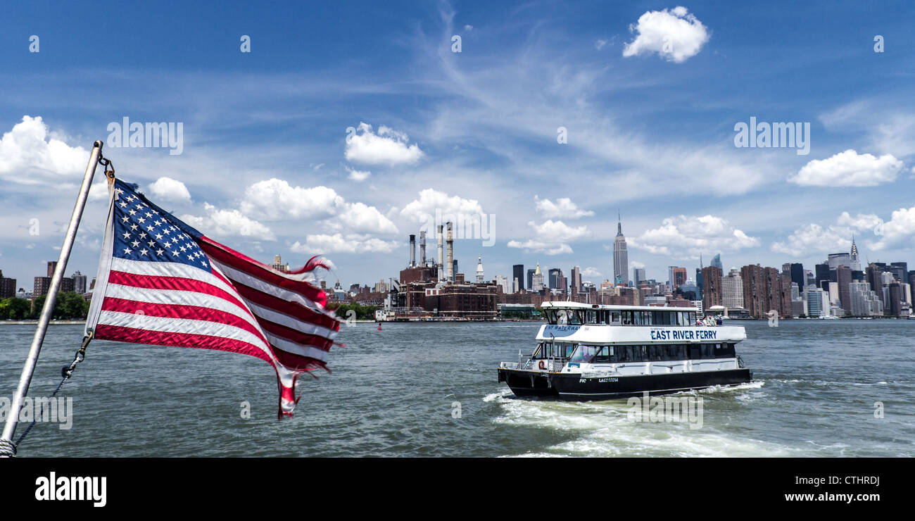 Ferry de la rivière East, drapeau américain, vue à Midtown Manhattan, New York Banque D'Images