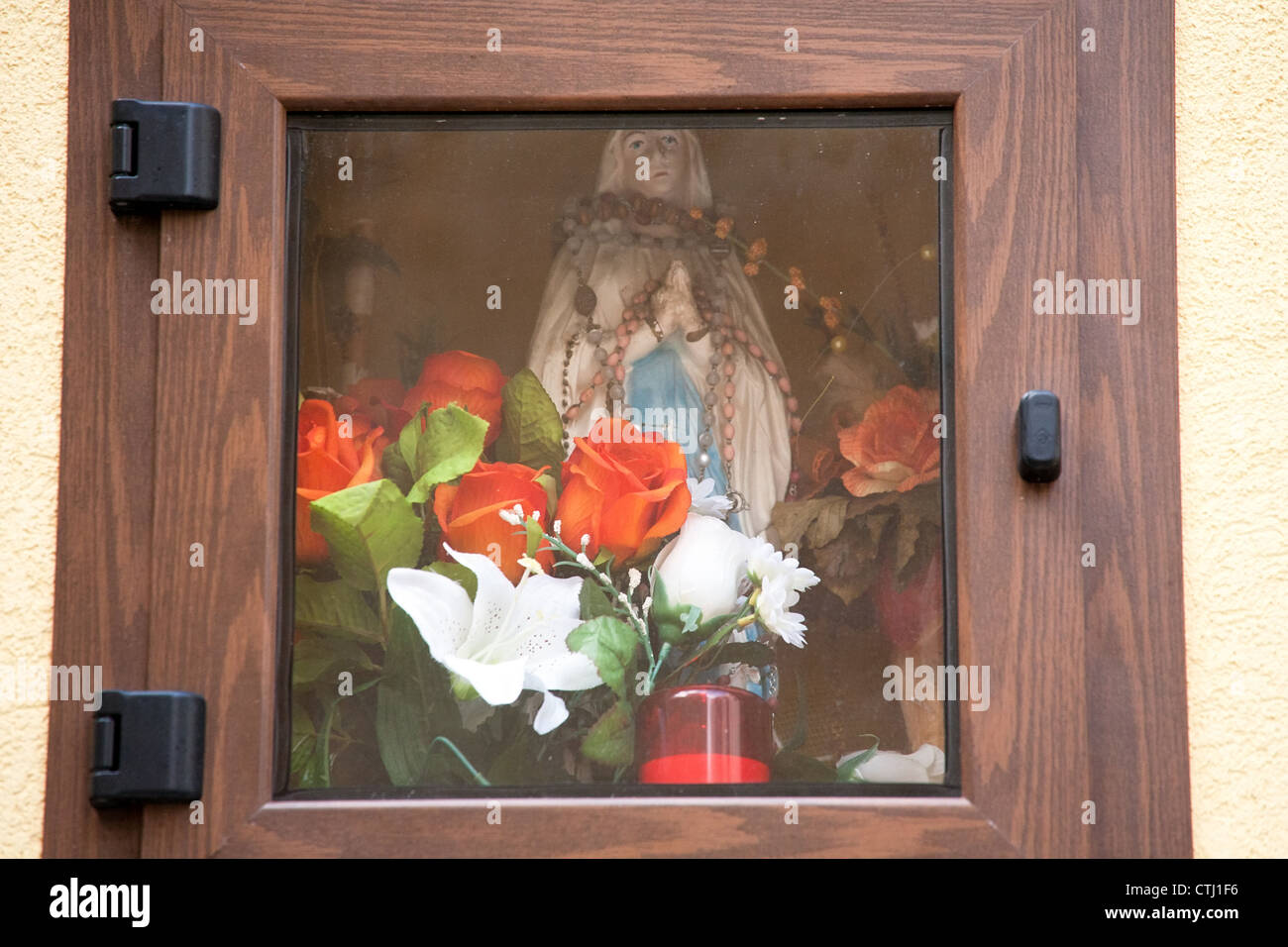 Niche dans le mur avec la Vierge Marie, statuette, bougie et des fleurs, Sicile, Italie Banque D'Images