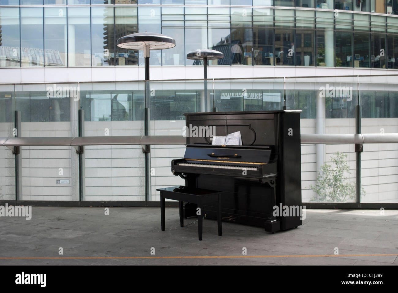Tabouret de piano et seul sur la passerelle soulevées en dehors de Londres  avec rambarde et à la façade de verre du bâtiment moderne en arrière-plan  Photo Stock - Alamy