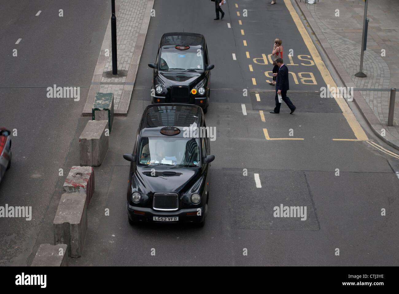 Regardant vers le bas sur deux les taxis noirs de Londres sur London Street à partir de ci-dessus avec plusieurs piétons Banque D'Images