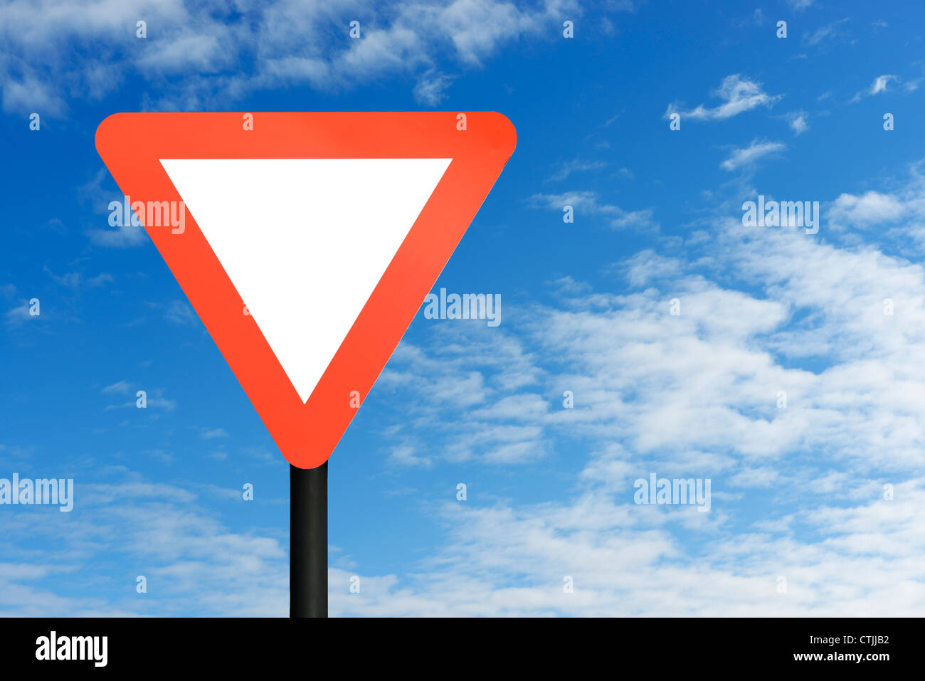Panneau routier triangulaire vierge rouge et bleu ciel Banque D'Images