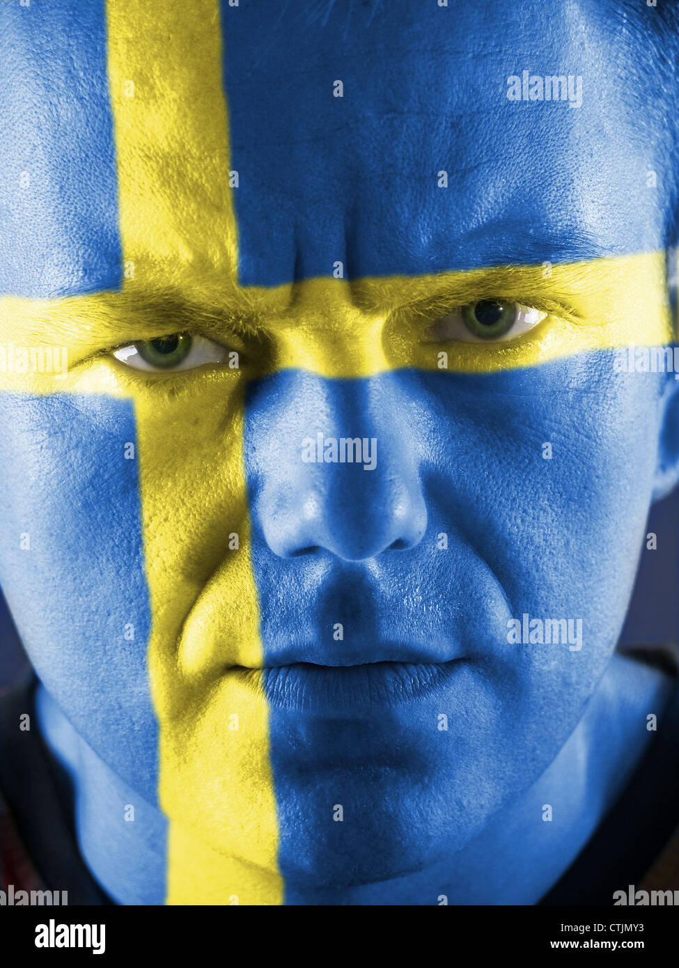 Gros plan du jeune défenseur suédois face peint en bleu avec croix jaune. Banque D'Images