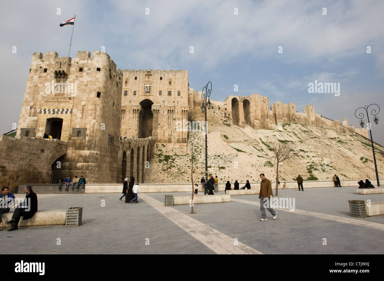 Des gens assis et en passant devant la porte d'entrée à la Citadelle d'Alep, Syrie Banque D'Images