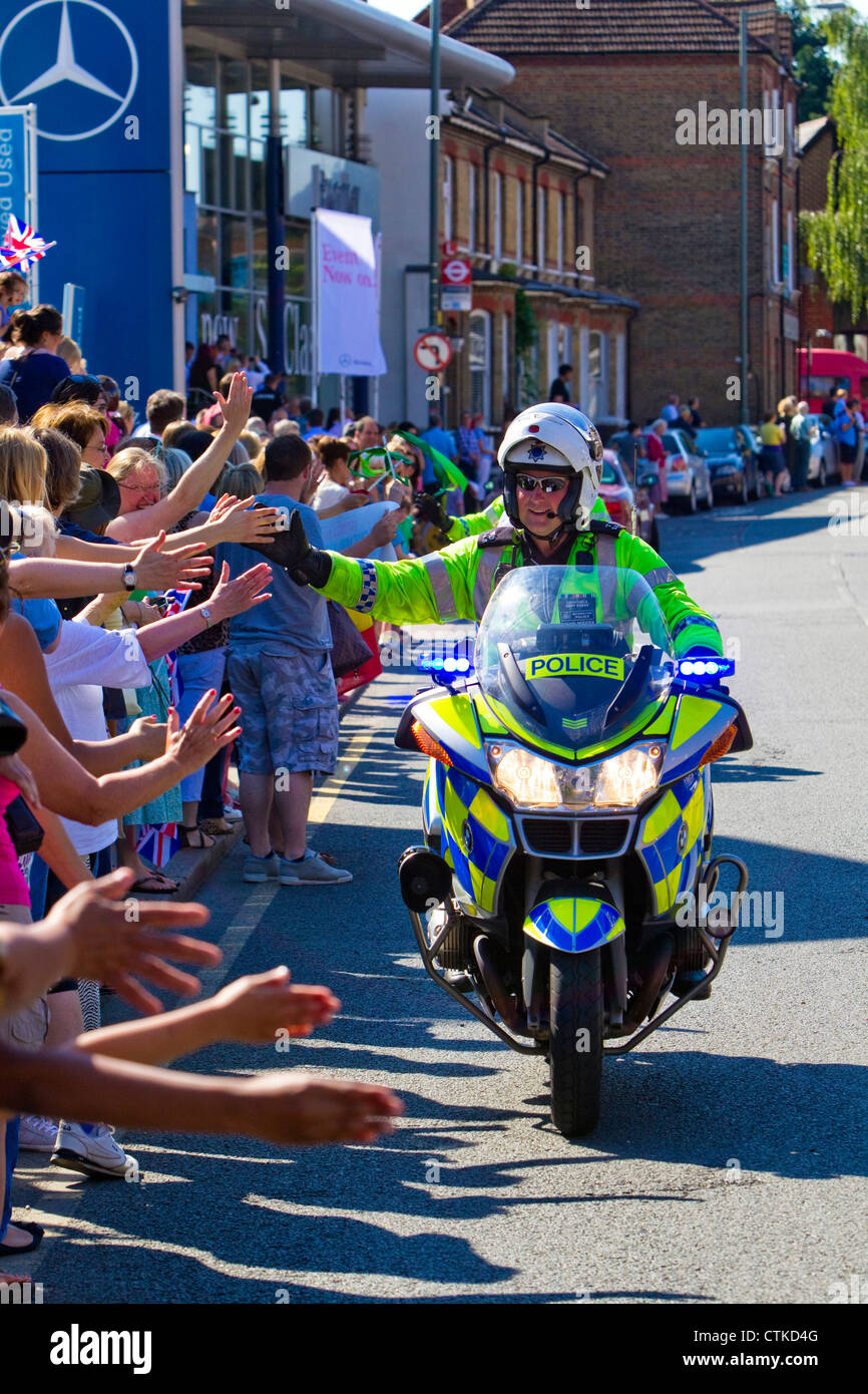 Un agent de police métropolitaine actions motocycliste '5' avec foule pendant le relais de la Flamme Olympique, Londres, juillet 2012. Banque D'Images