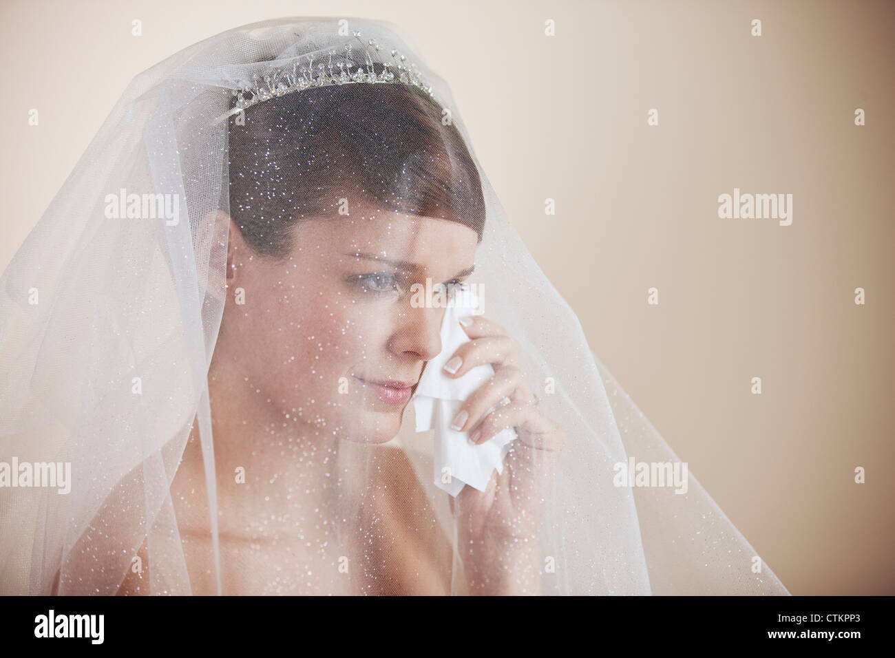 Une jeune épouse d'essuyer les larmes de son visage avec un mouchoir Banque D'Images