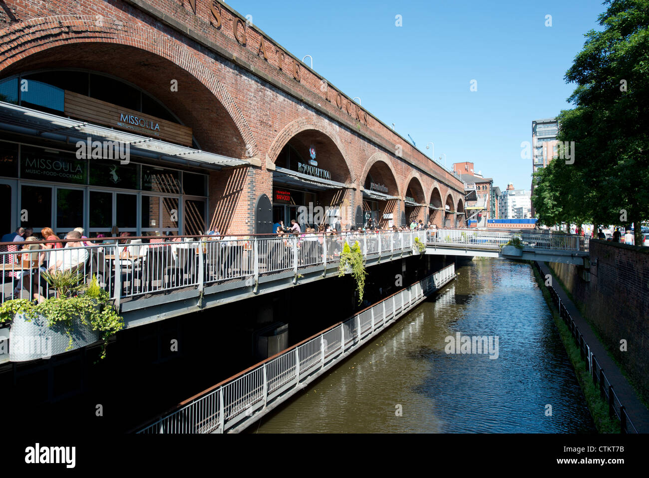 Les gens aiment socialiser avec un verre dans le soleil d'été à Deansgate Locks à Manchester. Banque D'Images