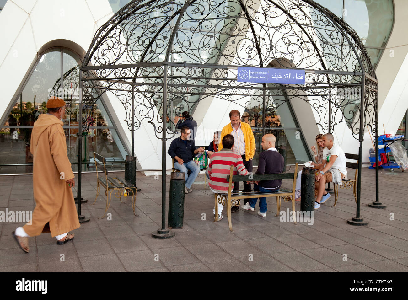 Les gens dans la zone fumeurs permis du terminal, l'aéroport de Marrakech, Maroc Sud Banque D'Images