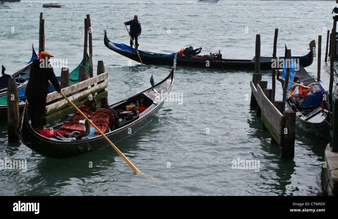 Venise, Italie- un jeune couple dans une gondole avec gondolier de partir dans la lagune, le Bacino San Marco Banque D'Images