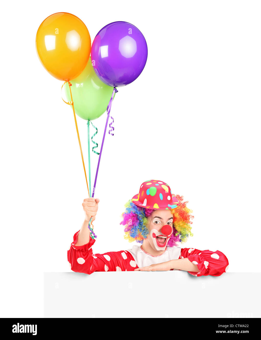 Un homme heureux avec clown expression de joie sur son visage posant derrière un panneau et holding balloons isolé sur fond blanc Banque D'Images
