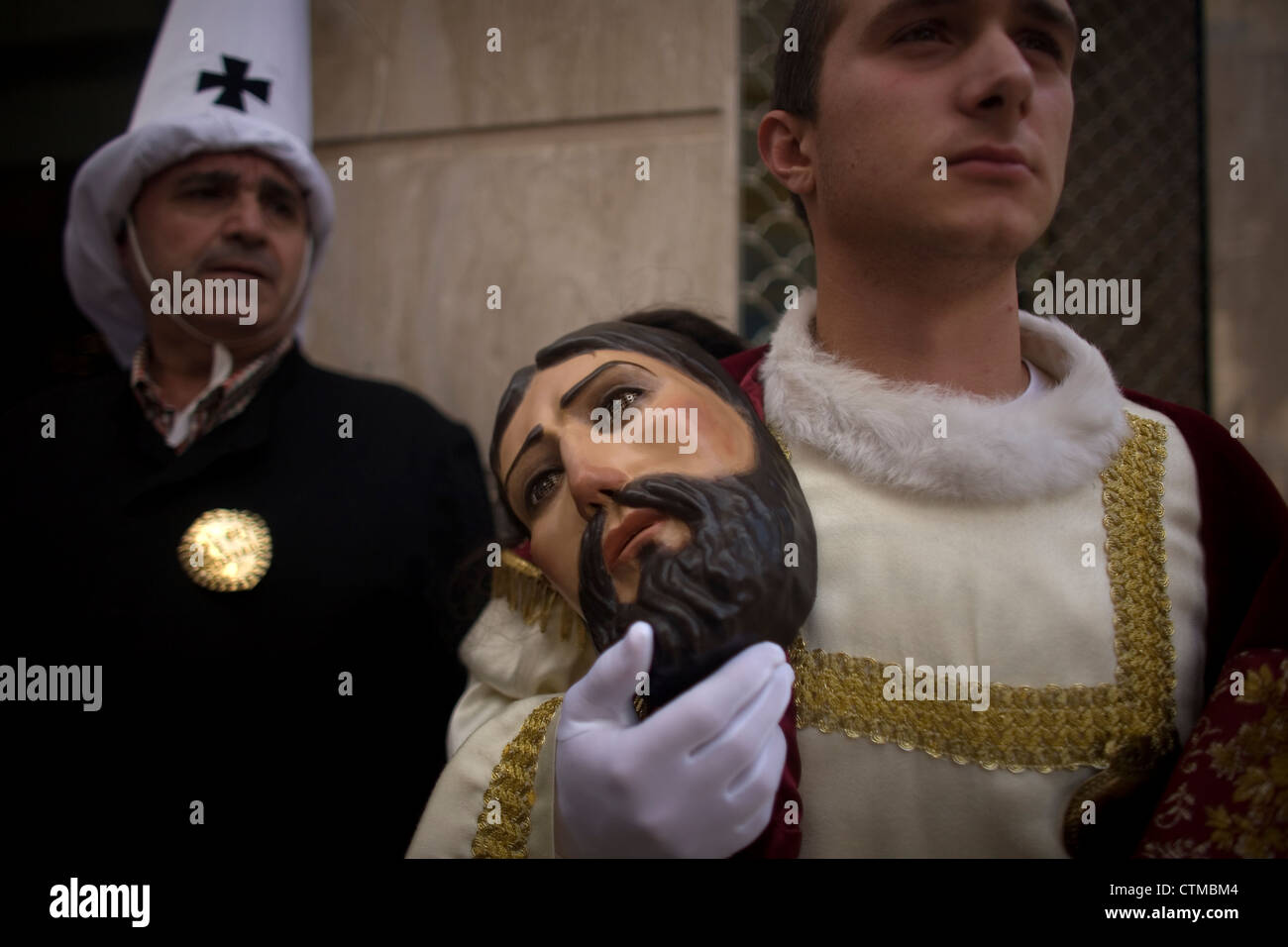Un homme est titulaire d'un masque lors d'une procession de la Semaine Sainte de Pâques à Puente Genil, dans la province de Cordoue, Andalousie, Espagne Banque D'Images