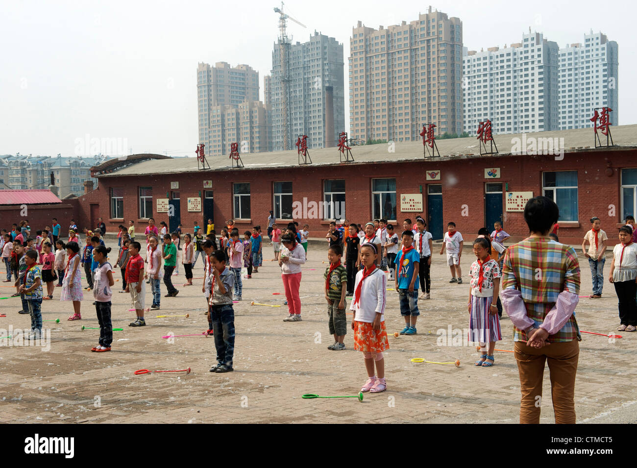 Les élèves n'exercices gymniques radio dans une école primaire pour les enfants des travailleurs migrants dans la région de Harbin, Heilongjiang, Chine. 2012 Banque D'Images