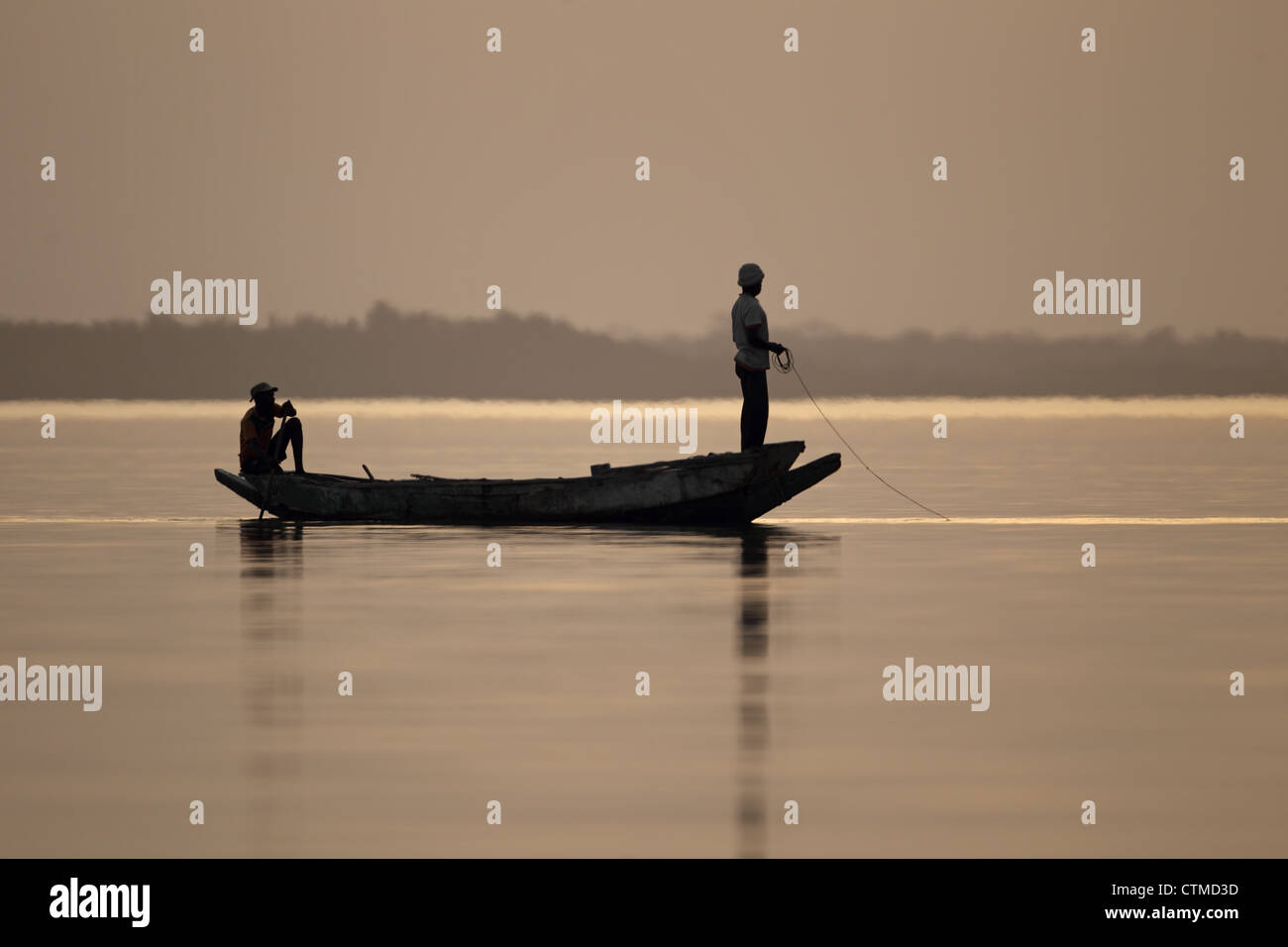 Les pêcheurs de la rivière Gambie en silhouette Banque D'Images