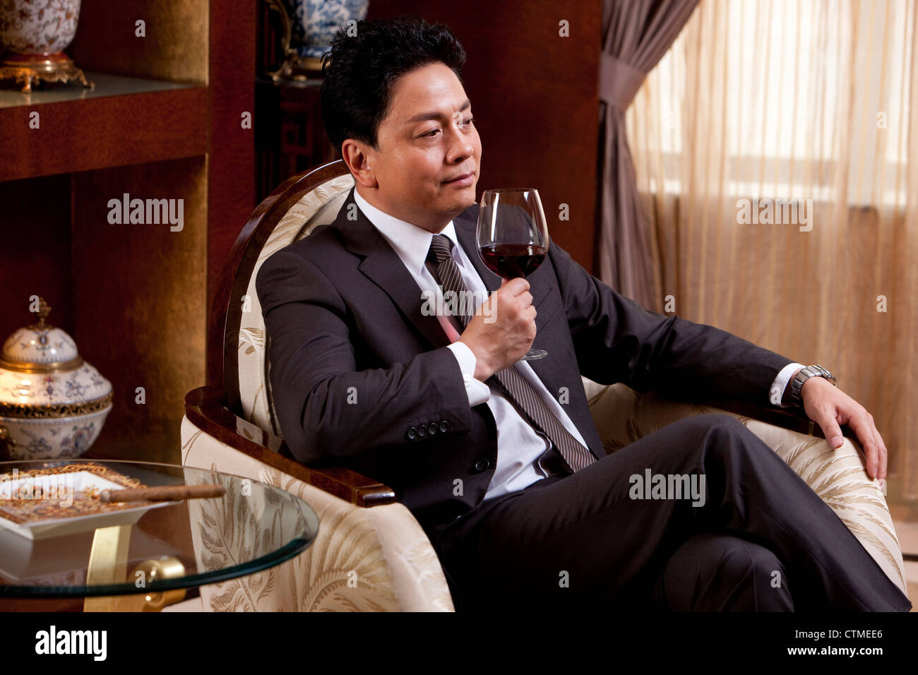 Man enjoying wine dans une chambre de luxe Banque D'Images