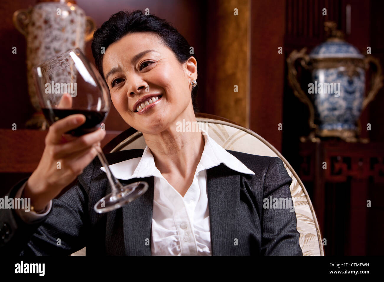 Vin mature businesswoman bénéficiant dans une chambre de luxe Banque D'Images
