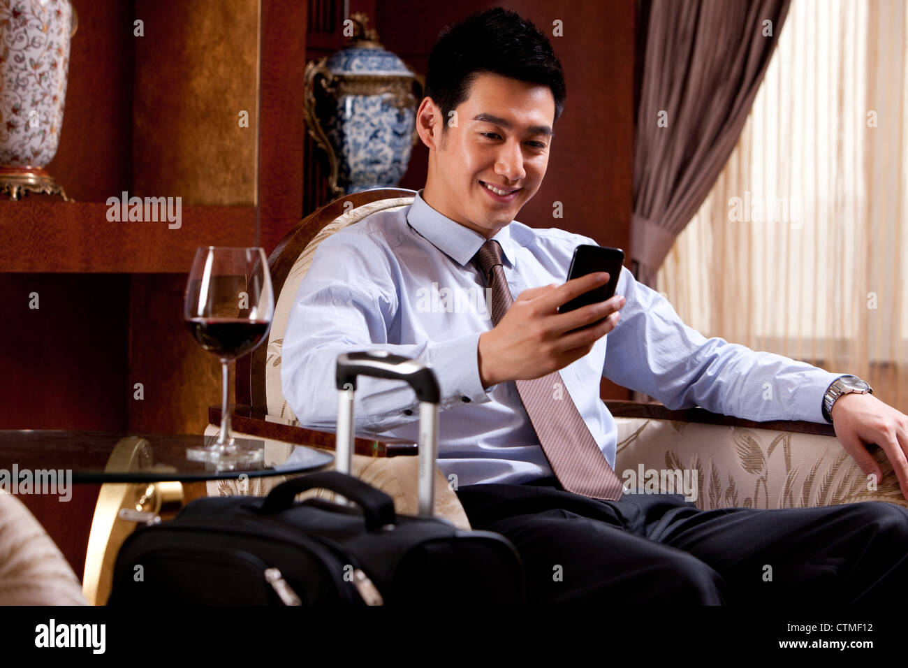 Young businessman using mobile phone in hotel Banque D'Images
