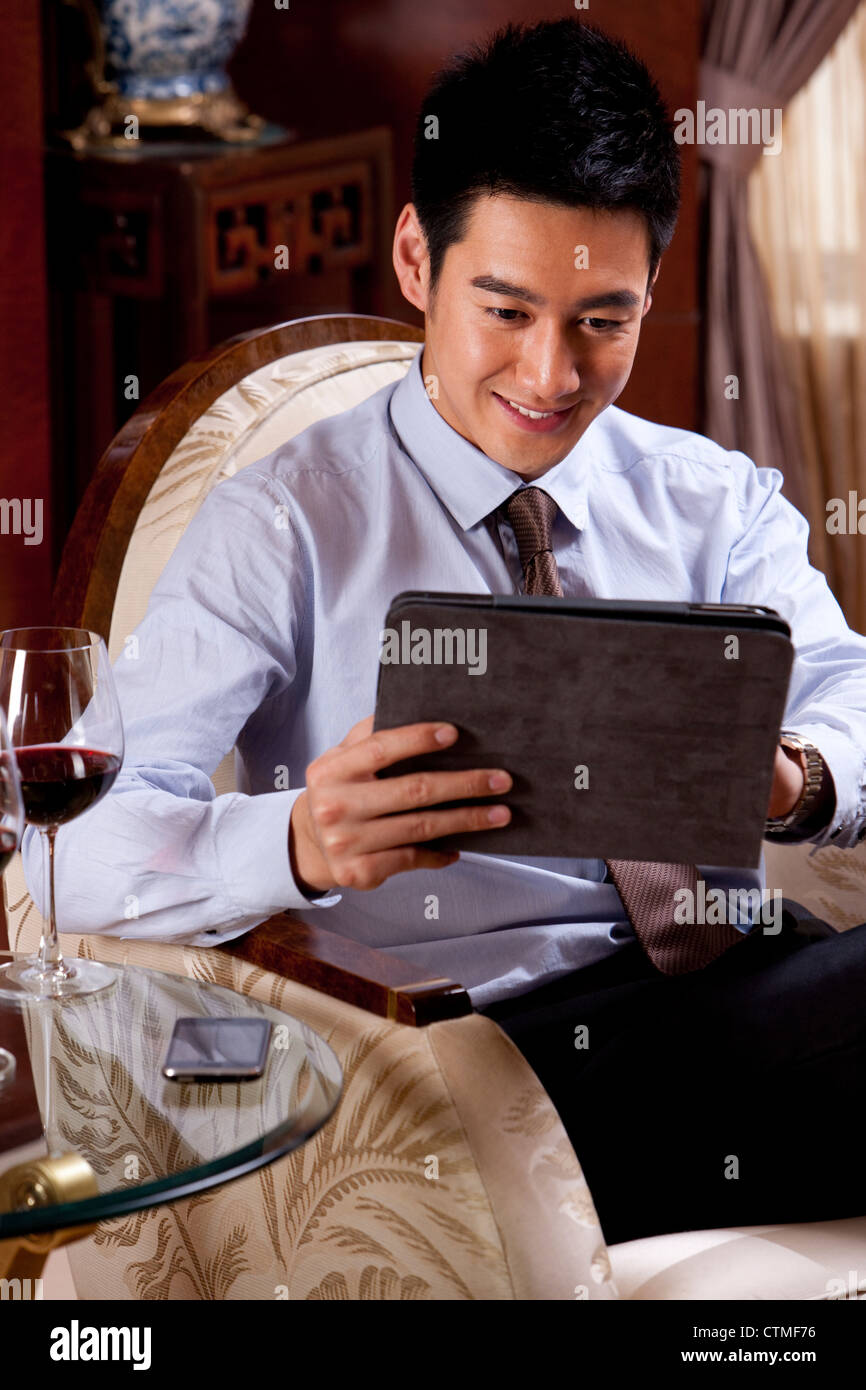 Young businessman using digital tablet in hotel Banque D'Images