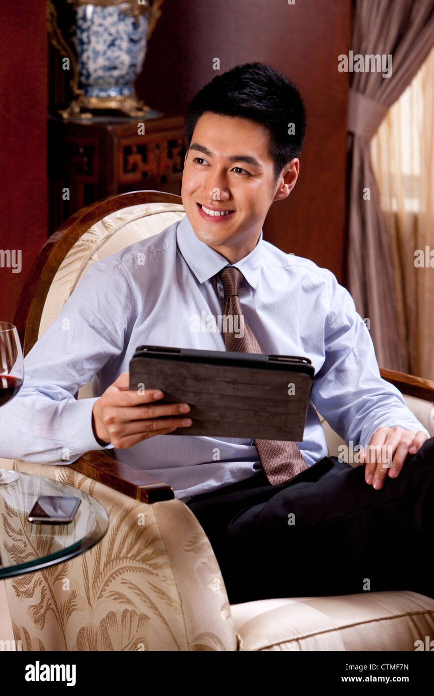 Young businessman using digital tablet in hotel Banque D'Images