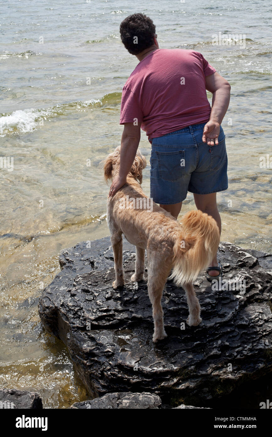 Une femme et son chien profiter du lac Michigan dans le comté de porte, au Wisconsin. Banque D'Images