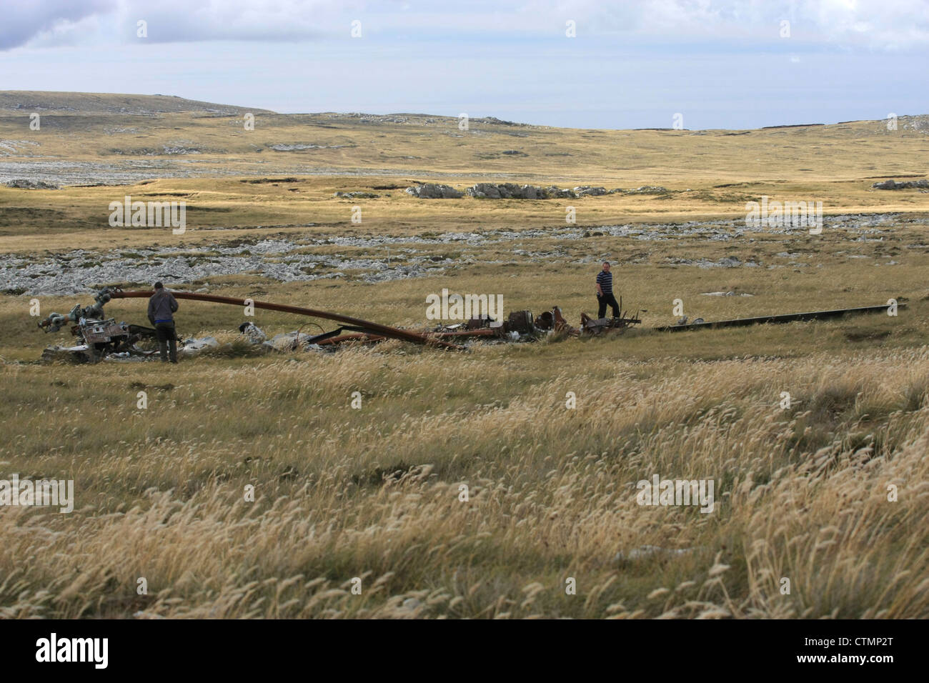 Deux hommes inspecter l'épave d'un hélicoptère sur East Falkland Island Banque D'Images