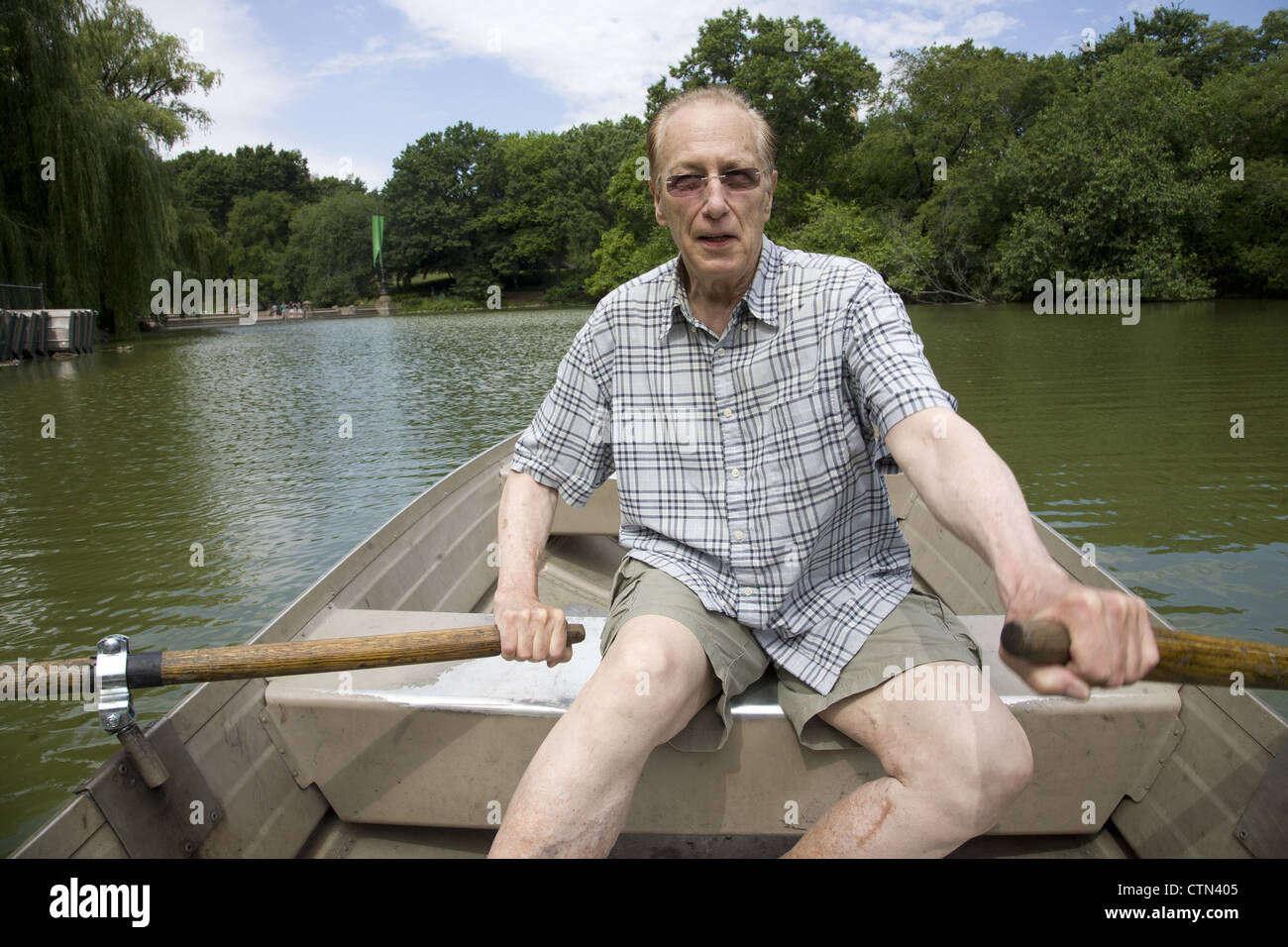 Homme en bonne santé dans son milieu des années 70 devient un peu d'exercice de l'aviron sur la voie navigable dans Central Park, New York City Banque D'Images