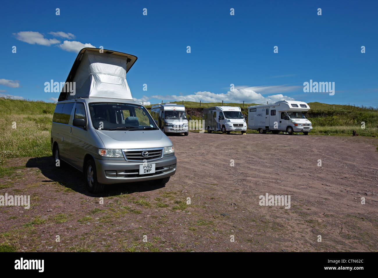 Mazda Bongo Frendee Campervan garé, avec sa toiture élevée avec trois autres motorhomes, Pembrokeshire, Pays de Galles, Royaume-Uni Banque D'Images