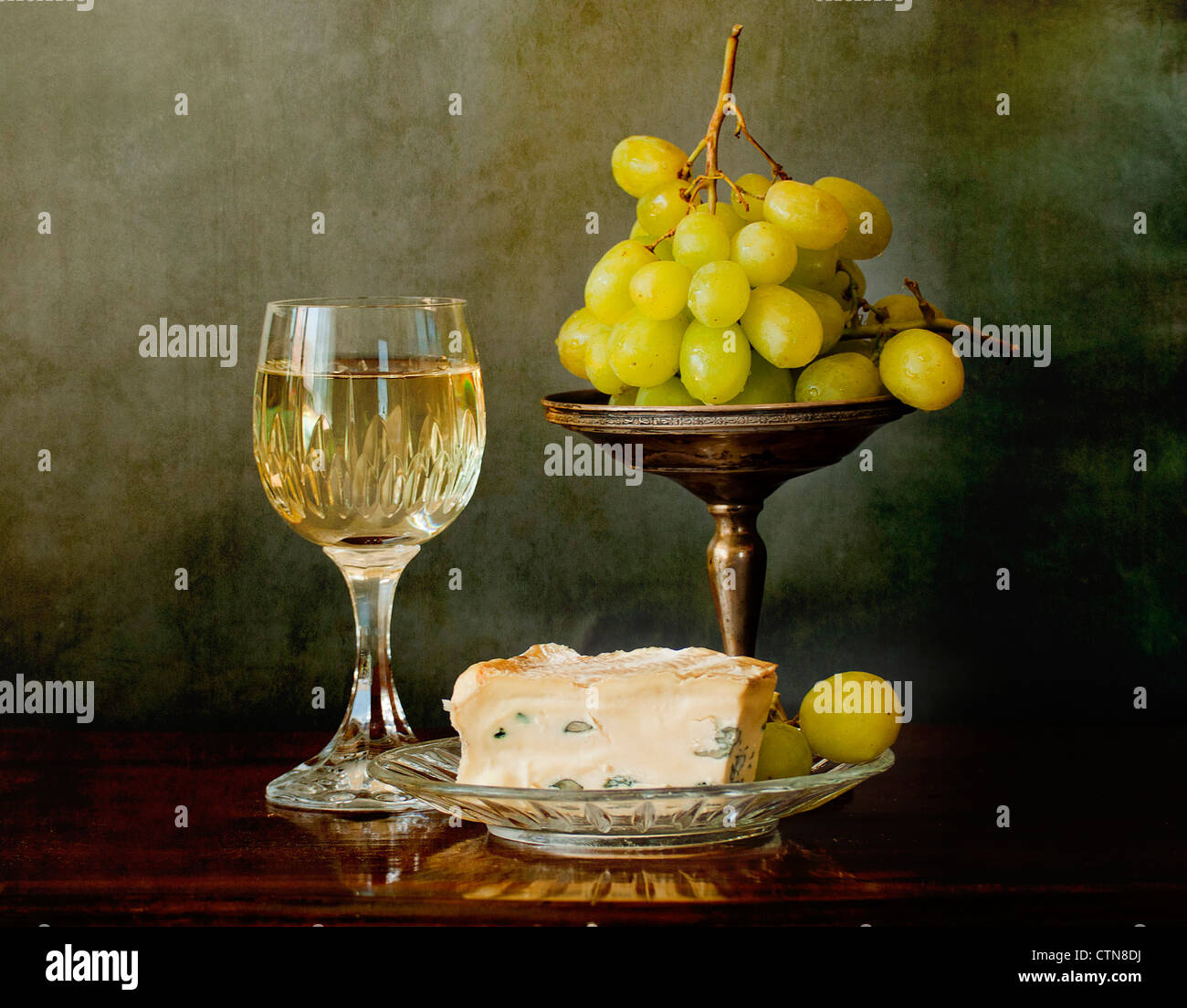 Un verre de vin blanc, des fromages français et des raisins Banque D'Images