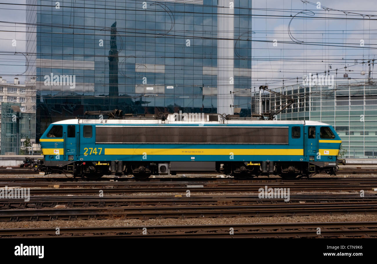 Une locomotive électrique de la classe 27 nombre 2747 en passant en face du bâtiment du siège de la sncb ,brussel zuid , Belgique Banque D'Images