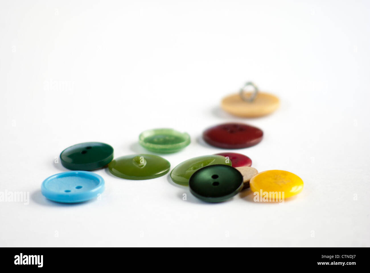 Une variété de couleurs uniques boutons recyclés sur un fond blanc. Banque D'Images