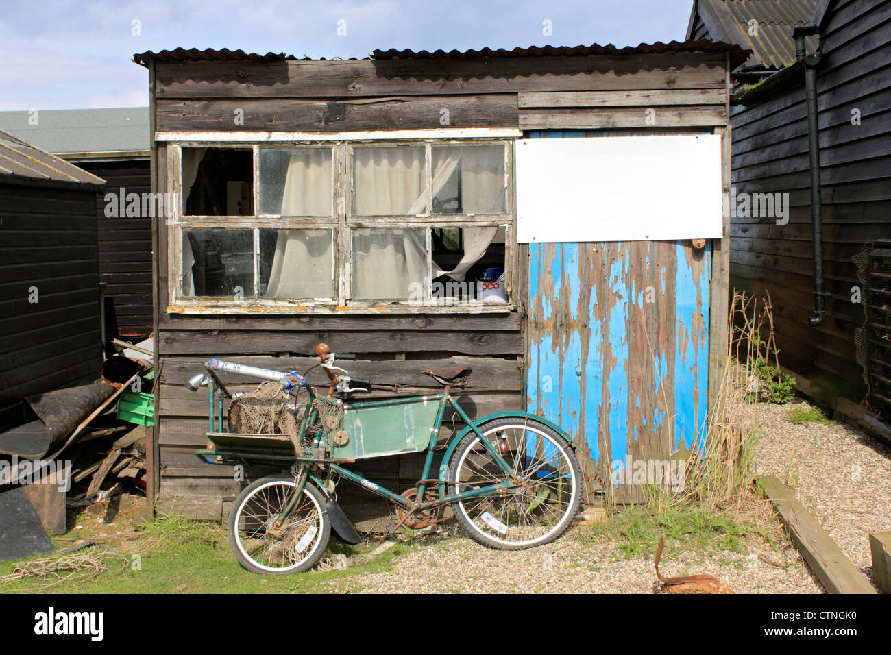 Vieux vélo rouillé contre shabby cabane de plage de Southwold, Suffolk, UK Angleterre Harbour Banque D'Images