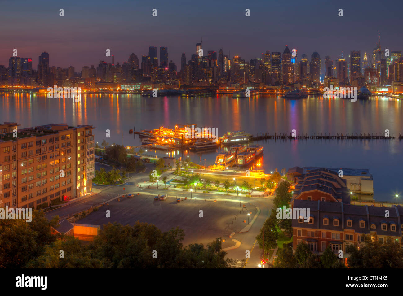 Une partie de l'horizon de Manhattan se reflète sur la surface de la Rivière Hudson au cours aube comme vu de New Jersey. Banque D'Images