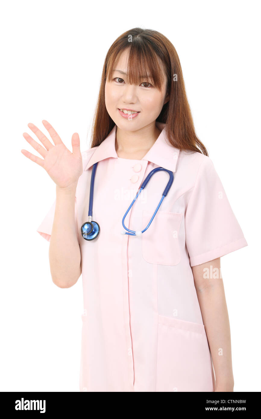 Young Asian female nurse en agitant la main Banque D'Images