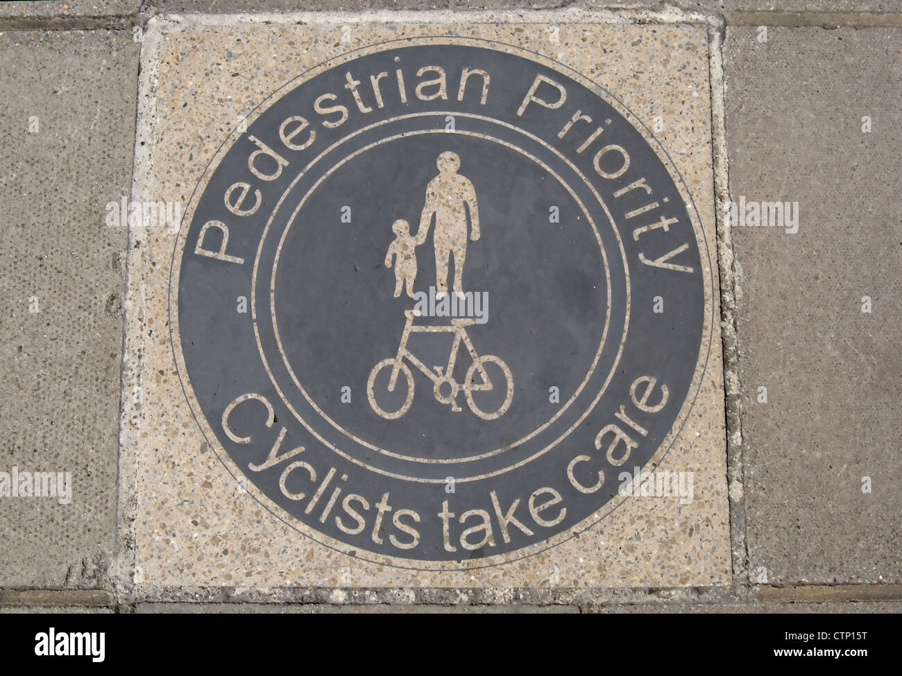 Priorité aux piétons cyclistes prendre soin paving slab signe à furnivall gardens, Hammersmith, Londres, Angleterre Banque D'Images