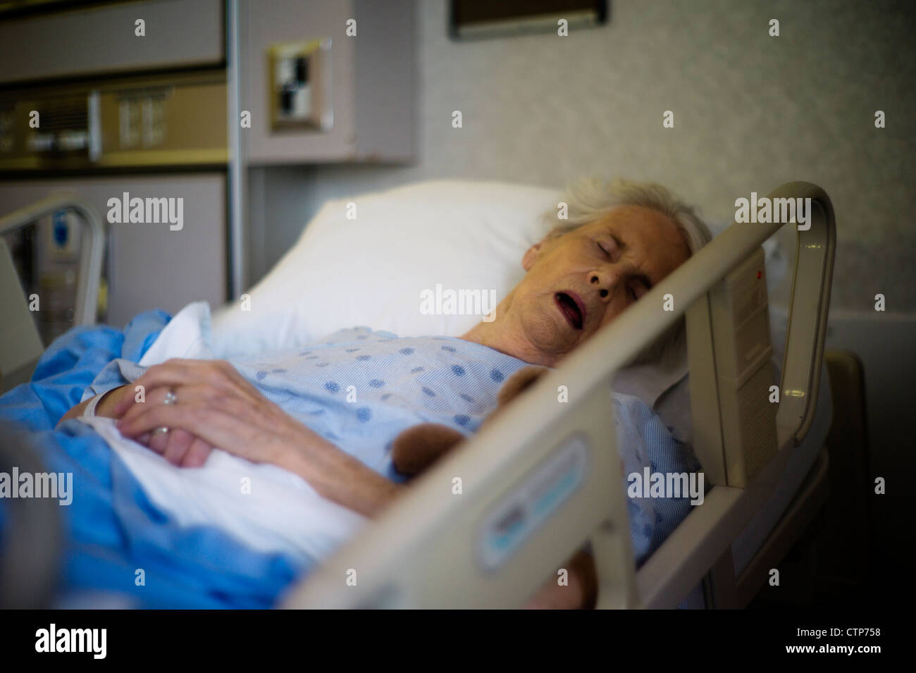 Vieille femme endormie sur un lit d'hôpital. Banque D'Images
