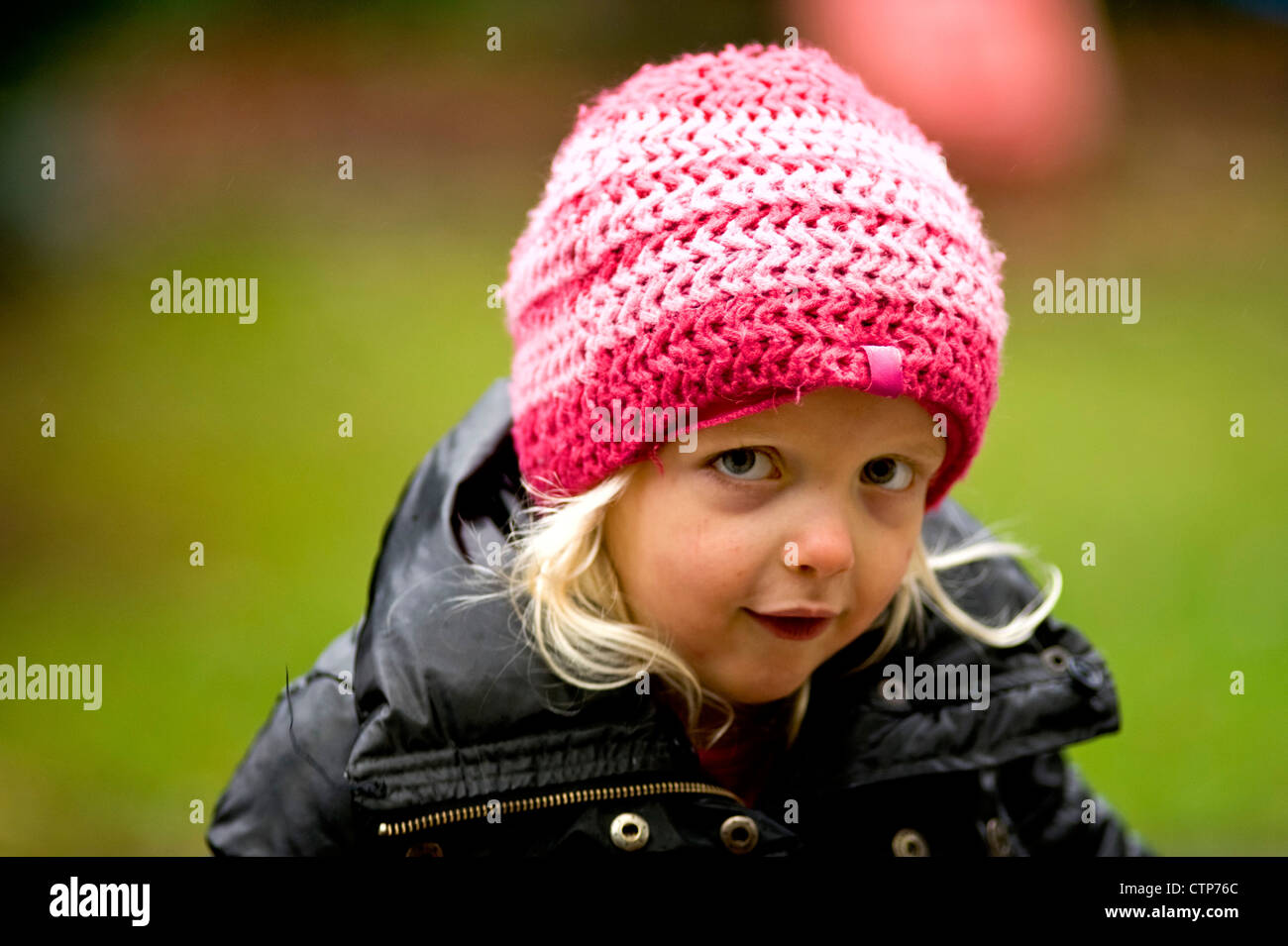 Portrait d'une petite fille avec un chapeau tricoté en laine rose Banque D'Images