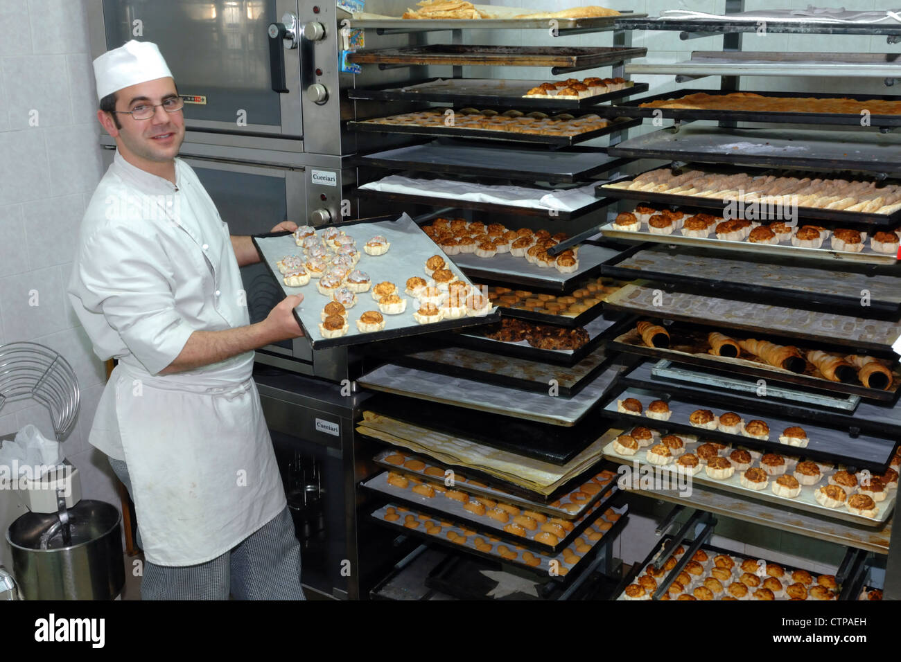 Chef pâtissier dans son atelier artisanal montre sa douce, Genoni, Sardaigne, Italie Banque D'Images