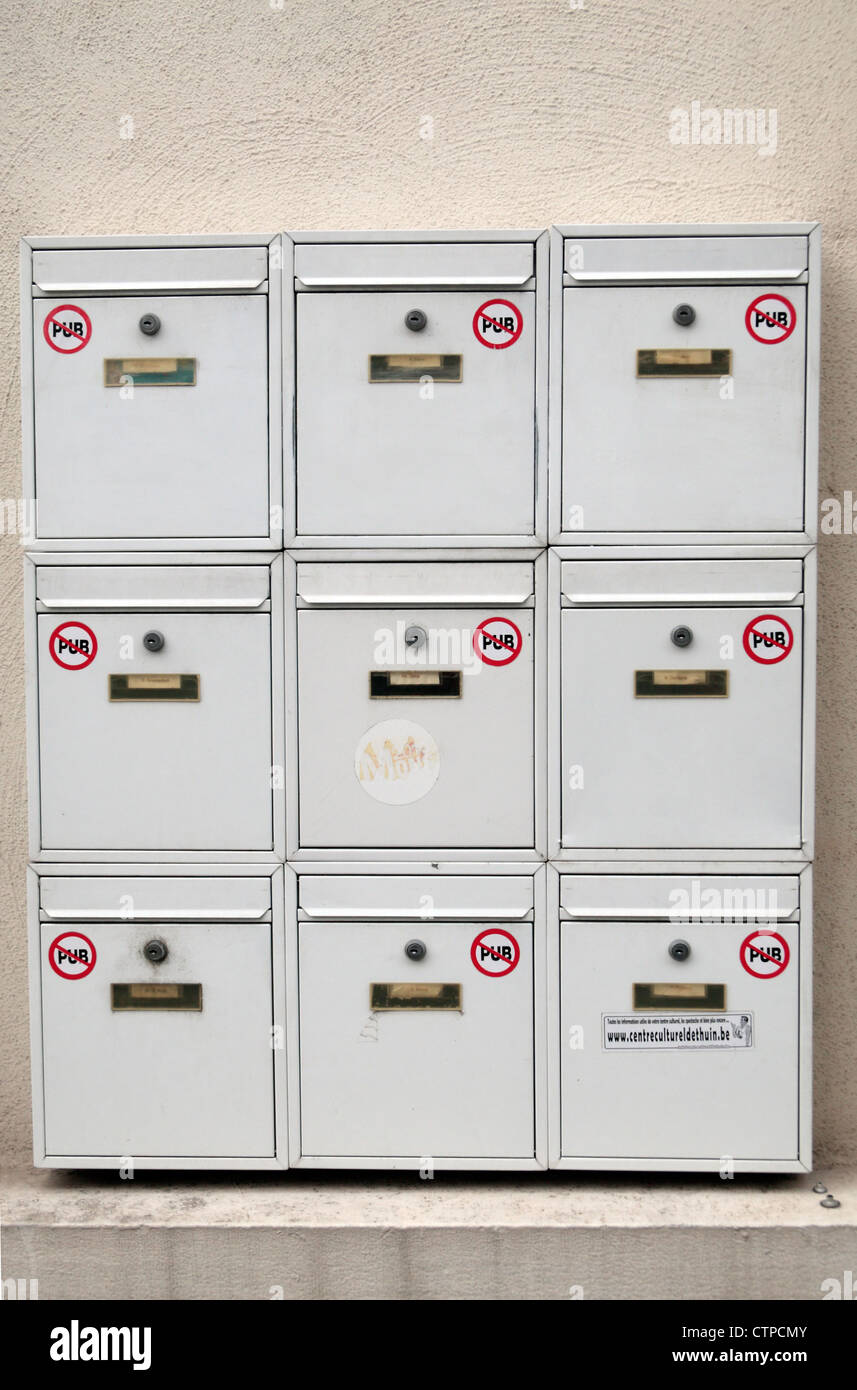 'PUB' ou 'Pas de publicité' autocollants (pas de courrier indésirable) sur une série d'immeuble d'mailboxs à Mons, Wallonie, région de Belgique. Banque D'Images