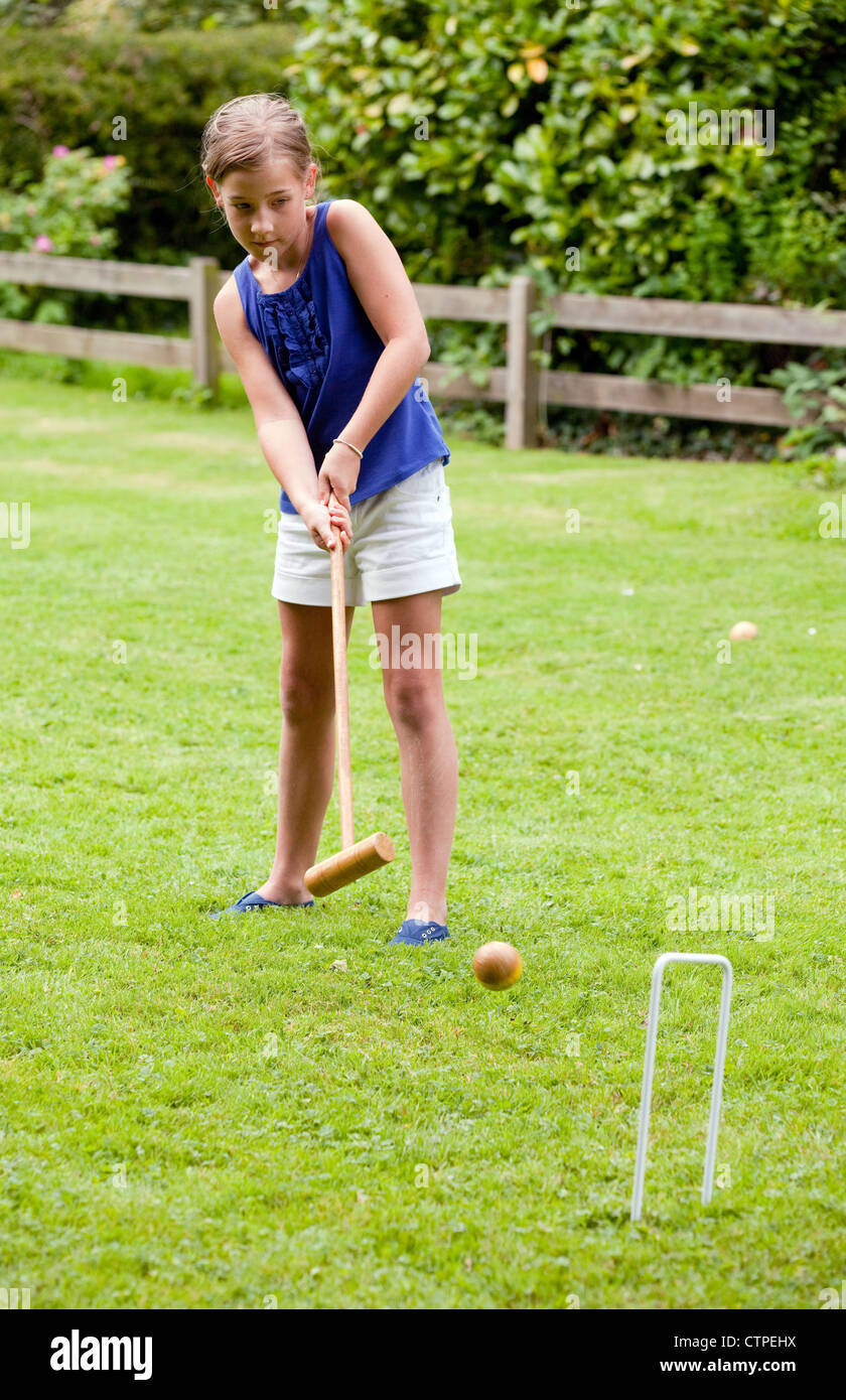 Jeune fille âgée de 10 ans de jouer au croquet, UK Banque D'Images