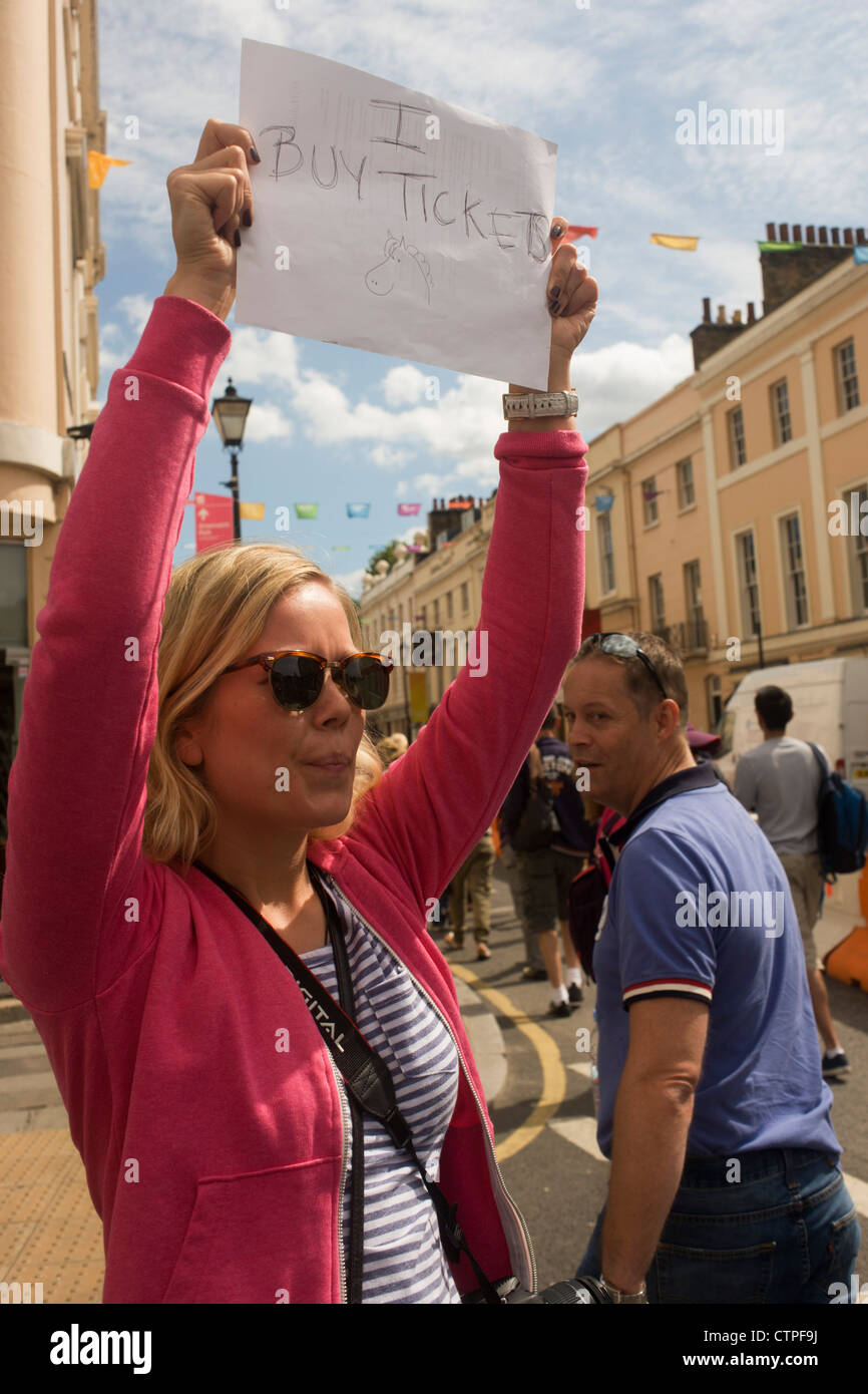 Jeux Olympiques Londres 2012 spectateur est titulaire d'un signe fait maison pour demander des billets équestres comme les visiteurs arrivent dans les vieilles rues de Greenwich, Londres. Le jour que 3 000 billets supplémentaires ont été mis en vente après les critiques de sièges vides à certains événements, les amateurs de sports étaient désespérés de voir le concours complet et de dressage au jour 4 de des jeux de Londres. Banque D'Images