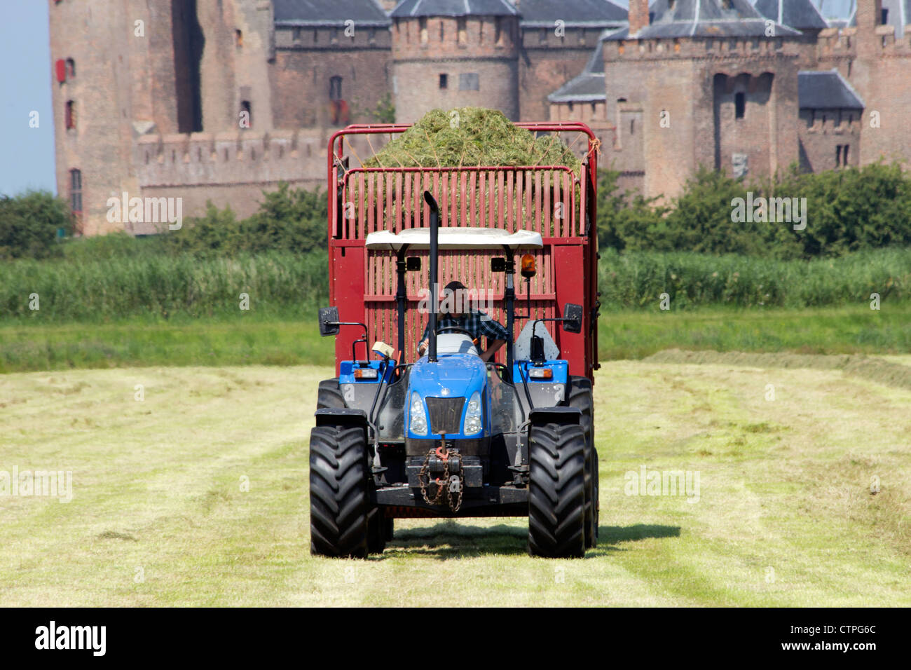 Agriculteur néerlandais sur un tracteur à l'avant du château Muiderslot en Hollande Banque D'Images